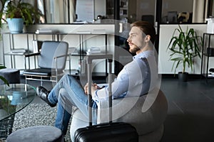 Capable millennial male expert travelling on business waiting for meeting