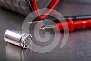 Capacitor and electrical meter. Measurement work in an electrical workshop