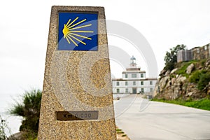 Cape Finisterre milestone, indicating the end of the Camino de Santiago with yellow seashell. Concept of reaching goals and