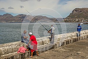 Anglers on the harbor wall at Kalk Bay South Africa