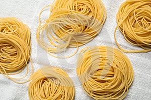 Capellini pasta on white tablecloth, flat lay
