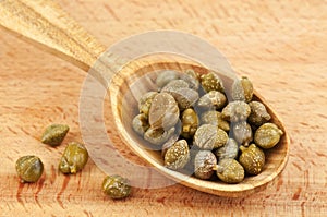 Capers in wooden spoon