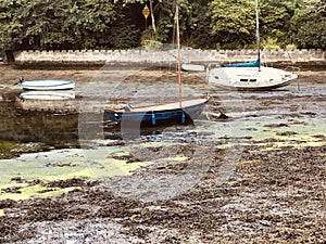 Capisized yacht at low tide in idyllic creek