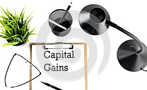 CAPITAL GAINS text on a clipboard on the white background