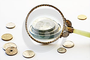 Capital increase, magnifying glass enlarge a few coins, bright g