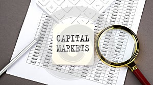 CAPITAL MARKETS text on sticker on the chart ,with calculator and magnifier