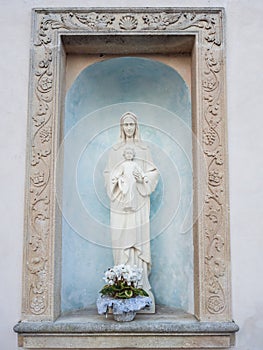 Capital with white votive statue of the Virgin Mary and baby Jesus in her arms