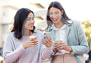 Capitalise on your network and wealth will come. two young businesswomen using a smartphone against an urban background.