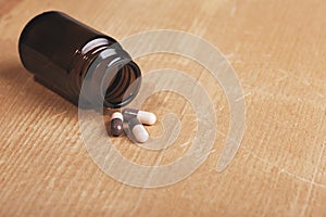 Caplets or pills in front of the opening medicine bottle