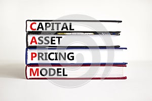 CAPM capital asset pricing model symbol. Concept words CAPM capital asset pricing model on books on a beautiful white background. photo