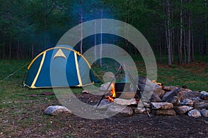 Capming site with a tent and open fire with a black pot photo