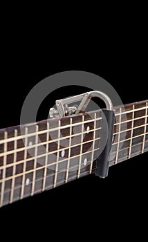 Capo on the Acoustic guitar neck , capro made from aluminium, Selective focus at capo