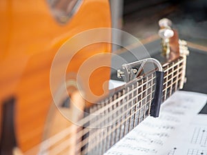 Capo on the Acoustic guitar neck , capro made from aluminium, Selective focus at capo