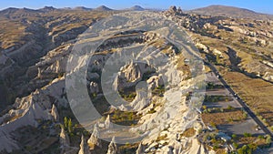 Cappadocia aerial drone view sandy volcanic formations and the road leading to the Uchisar Castle. Kayseri, Cappadocia