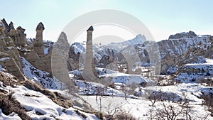 Cappadocia rock cave with rock carvings near the city of GÃ¶reme with snow during winter in central Turkey.