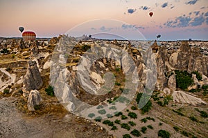 Cappadocia, Turkey - September 1, 2021 - Cappadocia Panoramic - Hot air balloon flying in early morning over rock landscape at