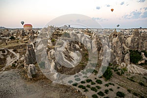 Cappadocia, Turkey - September 1, 2021 - Cappadocia Panoramic - Hot air balloon flying in early morning over rock landscape at