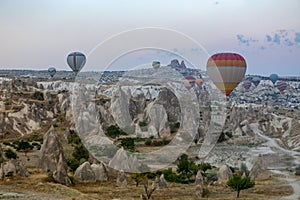 Cappadocia, Turkey - September 1, 2021 - Cappadocia Panoramic - Hot air balloon flying in early morning over rock landscape at