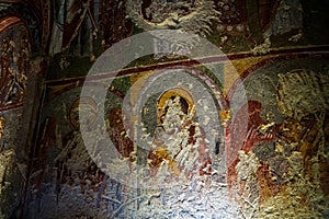 Cappadocia, Turkey - September 13, 2021: Early Christian mural. Saints, defaced gouged eyes, in rock carved Saint Barbara Church.