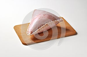 Cappello del prete salame in pork rind on cutting board