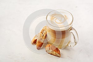 Cappuccino with biscotti or cantucci on a white table