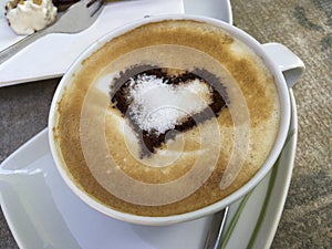 Cappuccino with a cocoa heart on decorated milk foam