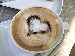 Cappuccino with a cocoa heart on decorated milk foam