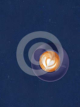 Cappuccino coffee on blue kraft paper texture. Top view.