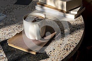 cappuccino coffee and books on an old table with a background of old rustic woods