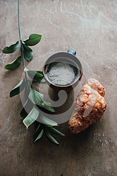 Cappuccino coffee and croissant on wooden background on the table. Perfect breakfast in the morning