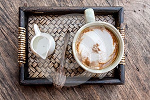 Cappuccino coffee cup with mini jar of syrup and wooden spoon a