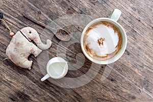 Cappuccino coffee cup with mini jar of syrup and wooden spoon a