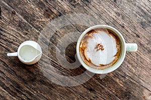 Cappuccino coffee cup with mini jar of syrup and wooden spoon a