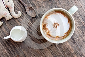 cappuccino coffee cup with mini jar of syrup and wooden spoon a