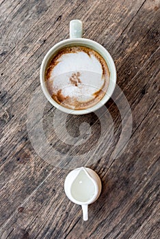 cappuccino coffee cup with mini jar of syrup and wooden spoon a