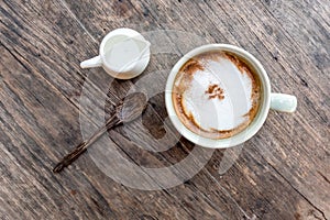 cappuccino coffee cup with mini jar of syrup and wooden spoon a