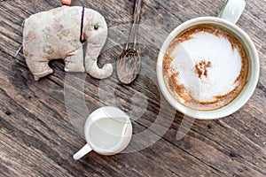 cappuccino coffee cup with mini jar of syrup and wooden spoon a