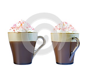 Cappuccino coffee in a glass mug with whipped cream, decorated with red pastry balls. Isolate on a white background.