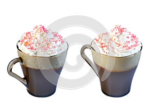 Cappuccino coffee in a glass mug with whipped cream, decorated with red pastry balls. Isolate on a white background.