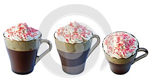 Cappuccino coffee in a glass mug with whipped cream, decorated with red pastry balls. Isolate on a white background.