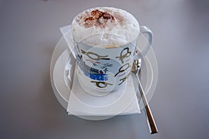 Cappuccino coffee in porcelain cup with instructions of knot bin