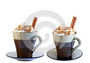 Cappuccino coffee, with whipped cream and ground cinnamon in a glass mug, on a saucer. Cinnamon stick. Isolate on a white backgrou