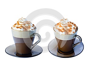 Cappuccino coffee, with whipped cream and ground cinnamon in a glass mug, on a saucer. Isolate on a white background.