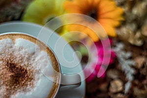 Cappuccino coffee on wooden table and sunlight background