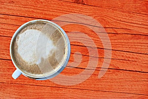 Cappuccino cup of coffee top view on an orange wooden rustic table