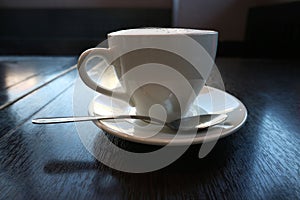 Cappuccino Cup side view stands on the table.