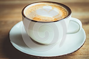 Cappuccino, cup, white, table, cafe, home. A beautiful background with a white cup of cappuccino on the wooden table. Close up