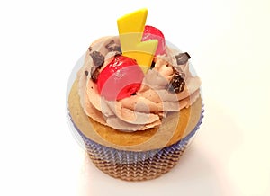 Cappuccino cupcake with a yellow candy and a red cherry on top