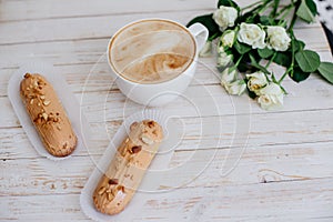 Cappuccino, eclairs and flowers.