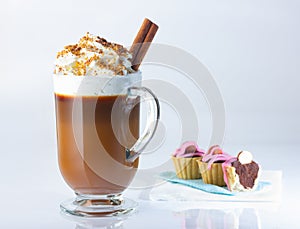 Cappuccino in a glass, Irish glass, cinnamon stick, ground nut and chocolate chips.Tartlets with chocolate paste and hazelnuts, co